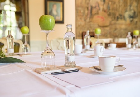 Für die Tagung eingedeckter Saal mit grünem Apfel und Schloss Bückeburg Artikeln