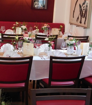 Festlich dekorierte Tische im Lillys mit Blumenschmuck und Menükarten