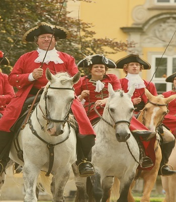 Gewandete Reiter auf Pferden