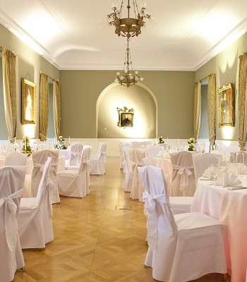 Gartensaal mit olivgrünen Wänden und festlich eingedeckten Tischen